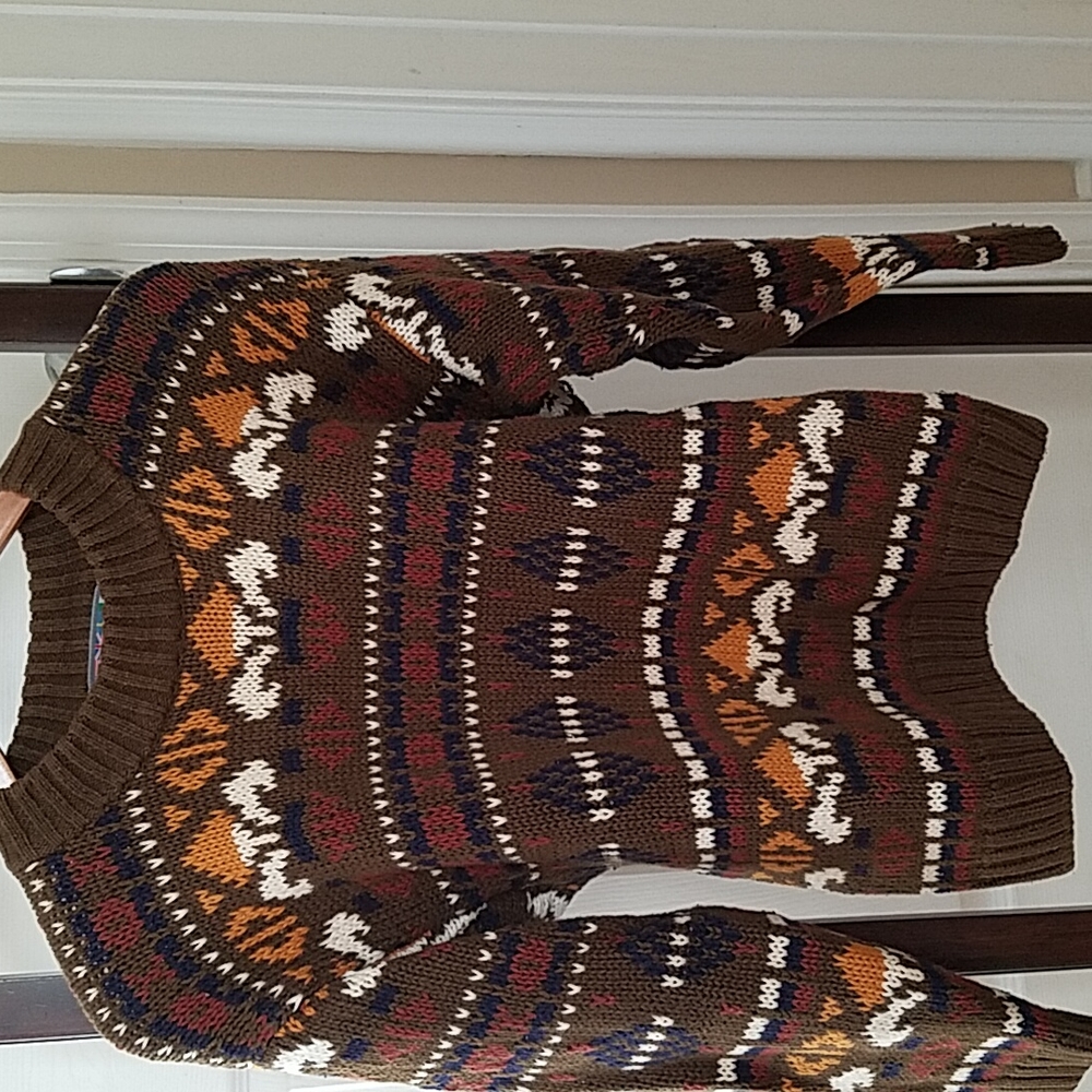 Geometric patterned sweater with a darj olive green backgound with earth tones.